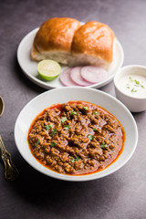 Kheema / keema Pav or Khima Paav is a spicy curry dish made up of minced chicken or lamb cooked with onion, tomatoes, served with buns. selective focus