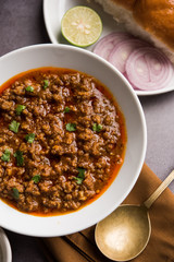 Kheema / keema Pav or Khima Paav is a spicy curry dish made up of minced chicken or lamb cooked with onion, tomatoes, served with buns. selective focus