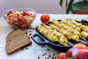 chicken skewers in a pan with pepper salad and tomato and spices