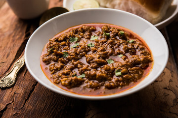 Kheema / keema Pav or Khima Paav is a spicy curry dish made up of minced chicken or lamb cooked with onion, tomatoes, served with buns. selective focus