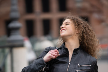 Happy young woman with curly hair walking around the streets of Rome, Italy