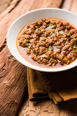 Kheema / keema Pav or Khima Paav is a spicy curry dish made up of minced chicken or lamb cooked with onion, tomatoes, served with buns. selective focus