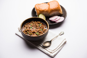Kheema / keema Pav or Khima Paav is a spicy curry dish made up of minced chicken or lamb cooked with onion, tomatoes, served with buns. selective focus