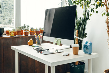 Office  or home workspace. Computer monitor with black screen on office table with supplies