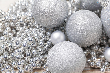 Shiny silver glitter baubles close up on wooden table