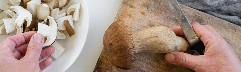 Personal perspective of woman hands preparing porcini mushrooms (Boletus edible) for cooking them