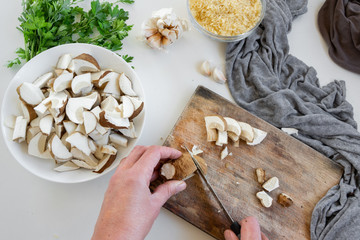 Personal perspective of woman hands preparing porcini mushrooms (Boletus edible) for cooking them