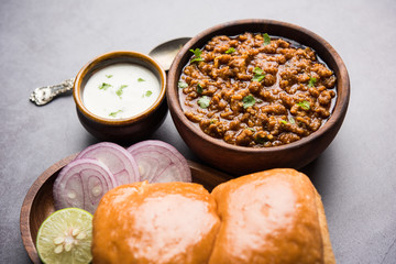 Kheema / keema Pav or Khima Paav is a spicy curry dish made up of minced chicken or lamb cooked with onion, tomatoes, served with buns. selective focus