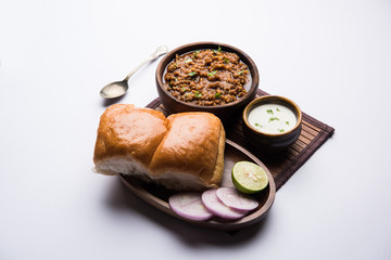 Kheema / keema Pav or Khima Paav is a spicy curry dish made up of minced chicken or lamb cooked with onion, tomatoes, served with buns. selective focus