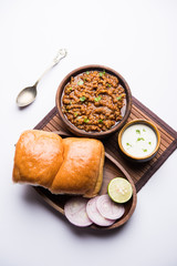 Kheema / keema Pav or Khima Paav is a spicy curry dish made up of minced chicken or lamb cooked with onion, tomatoes, served with buns. selective focus