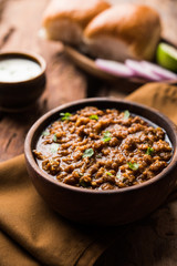 Kheema / keema Pav or Khima Paav is a spicy curry dish made up of minced chicken or lamb cooked with onion, tomatoes, served with buns. selective focus