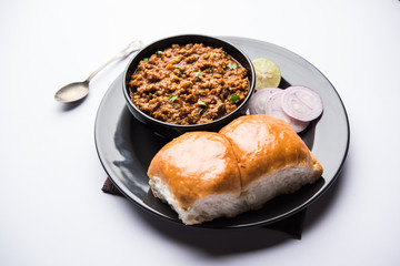 Kheema / keema Pav or Khima Paav is a spicy curry dish made up of minced chicken or lamb cooked with onion, tomatoes, served with buns. selective focus