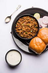 Kheema / keema Pav or Khima Paav is a spicy curry dish made up of minced chicken or lamb cooked with onion, tomatoes, served with buns. selective focus
