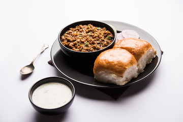 Kheema / keema Pav or Khima Paav is a spicy curry dish made up of minced chicken or lamb cooked with onion, tomatoes, served with buns. selective focus