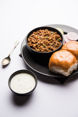 Kheema / keema Pav or Khima Paav is a spicy curry dish made up of minced chicken or lamb cooked with onion, tomatoes, served with buns. selective focus