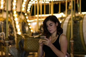 Young woman in a fair with her smartphone