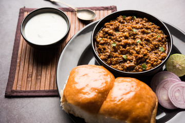 Kheema / keema Pav or Khima Paav is a spicy curry dish made up of minced chicken or lamb cooked with onion, tomatoes, served with buns. selective focus