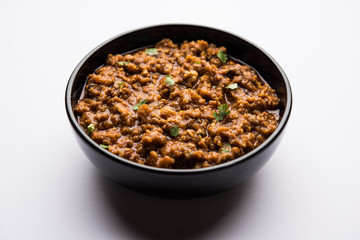 Kheema / keema Pav or Khima Paav is a spicy curry dish made up of minced chicken or lamb cooked with onion, tomatoes, served with buns. selective focus