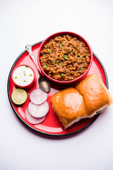 Kheema / keema Pav or Khima Paav is a spicy curry dish made up of minced chicken or lamb cooked with onion, tomatoes, served with buns. selective focus