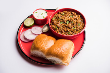 Kheema / keema Pav or Khima Paav is a spicy curry dish made up of minced chicken or lamb cooked with onion, tomatoes, served with buns. selective focus