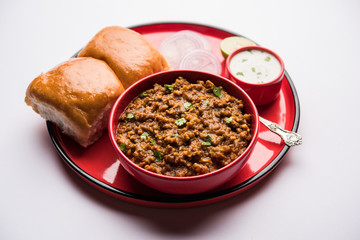 Kheema / keema Pav or Khima Paav is a spicy curry dish made up of minced chicken or lamb cooked with onion, tomatoes, served with buns. selective focus
