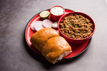 Kheema / keema Pav or Khima Paav is a spicy curry dish made up of minced chicken or lamb cooked with onion, tomatoes, served with buns. selective focus
