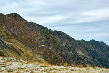 View of mountain range of Carpathian Mountains near Transfagarash highway in Romania. Tourist view mountain road. Autumn mountain landscape.