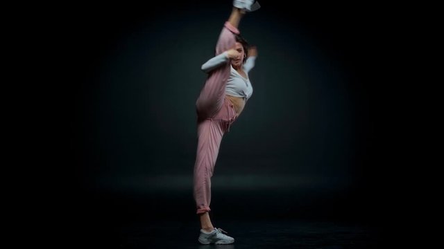 attractive girl doing gymnastics wheel on black 