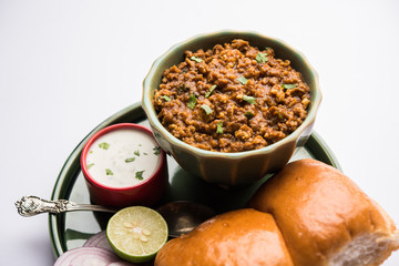 Kheema / keema Pav or Khima Paav is a spicy curry dish made up of minced chicken or lamb cooked with onion, tomatoes, served with buns. selective focus