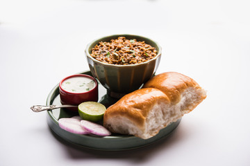 Kheema / keema Pav or Khima Paav is a spicy curry dish made up of minced chicken or lamb cooked with onion, tomatoes, served with buns. selective focus