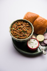 Kheema / keema Pav or Khima Paav is a spicy curry dish made up of minced chicken or lamb cooked with onion, tomatoes, served with buns. selective focus