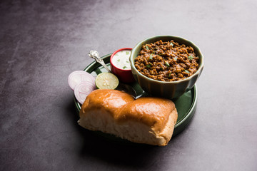 Kheema / keema Pav or Khima Paav is a spicy curry dish made up of minced chicken or lamb cooked with onion, tomatoes, served with buns. selective focus