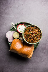 Kheema / keema Pav or Khima Paav is a spicy curry dish made up of minced chicken or lamb cooked with onion, tomatoes, served with buns. selective focus