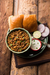 Kheema / keema Pav or Khima Paav is a spicy curry dish made up of minced chicken or lamb cooked with onion, tomatoes, served with buns. selective focus