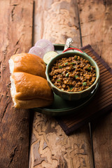 Kheema / keema Pav or Khima Paav is a spicy curry dish made up of minced chicken or lamb cooked with onion, tomatoes, served with buns. selective focus