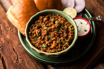 Kheema / keema Pav or Khima Paav is a spicy curry dish made up of minced chicken or lamb cooked with onion, tomatoes, served with buns. selective focus