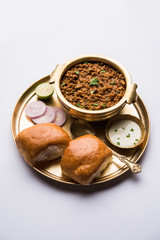 Kheema / keema Pav or Khima Paav is a spicy curry dish made up of minced chicken or lamb cooked with onion, tomatoes, served with buns. selective focus