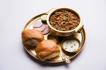 Kheema / keema Pav or Khima Paav is a spicy curry dish made up of minced chicken or lamb cooked with onion, tomatoes, served with buns. selective focus