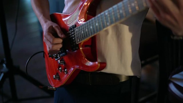Man playing guitar at a rock concert. Beautiful varnished guitar.