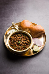 Kheema / keema Pav or Khima Paav is a spicy curry dish made up of minced chicken or lamb cooked with onion, tomatoes, served with buns. selective focus