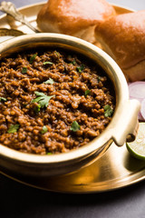 Kheema / keema Pav or Khima Paav is a spicy curry dish made up of minced chicken or lamb cooked with onion, tomatoes, served with buns. selective focus