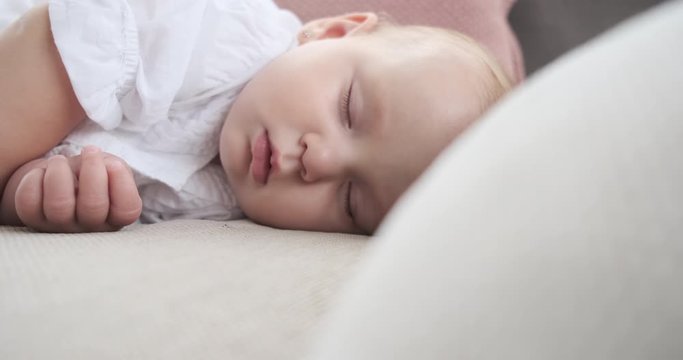Baby girl sleeping on bed at home