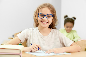 Smart girl posing while doing task during lesson