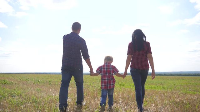 happy family walking nature teamwork friendship care concept slow motion video. father mom and son walk in nature sunset sunlight hold hand. happy family parents man and girl hold little boy a