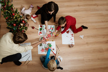 Family of five making holiday decorations