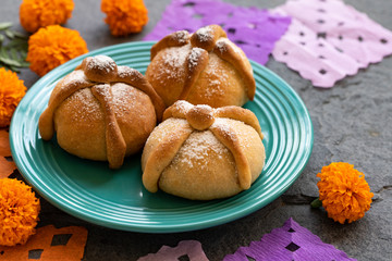 Mexican celebration, bread of death. Mexican parties with Dead bread and marigold flowers on gray stone background. Traditional Mexican Bread of the Dead Pan de Muerto .