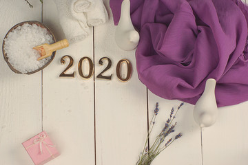 SPA set and golden numbers 2020 on a white plank background with a purple cloth.