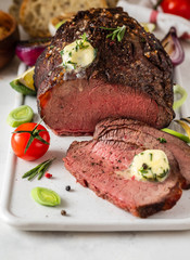 Roast beef with sauce and meat fork on white background. Copy space.