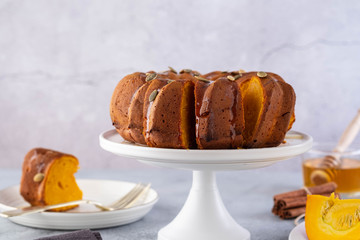Pumpkin cake with honey on a gray background. Copy space.