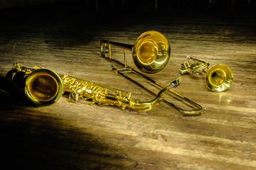 Brass and wind instruments - saxophone, trombone, trumpet on stage with backlight.
